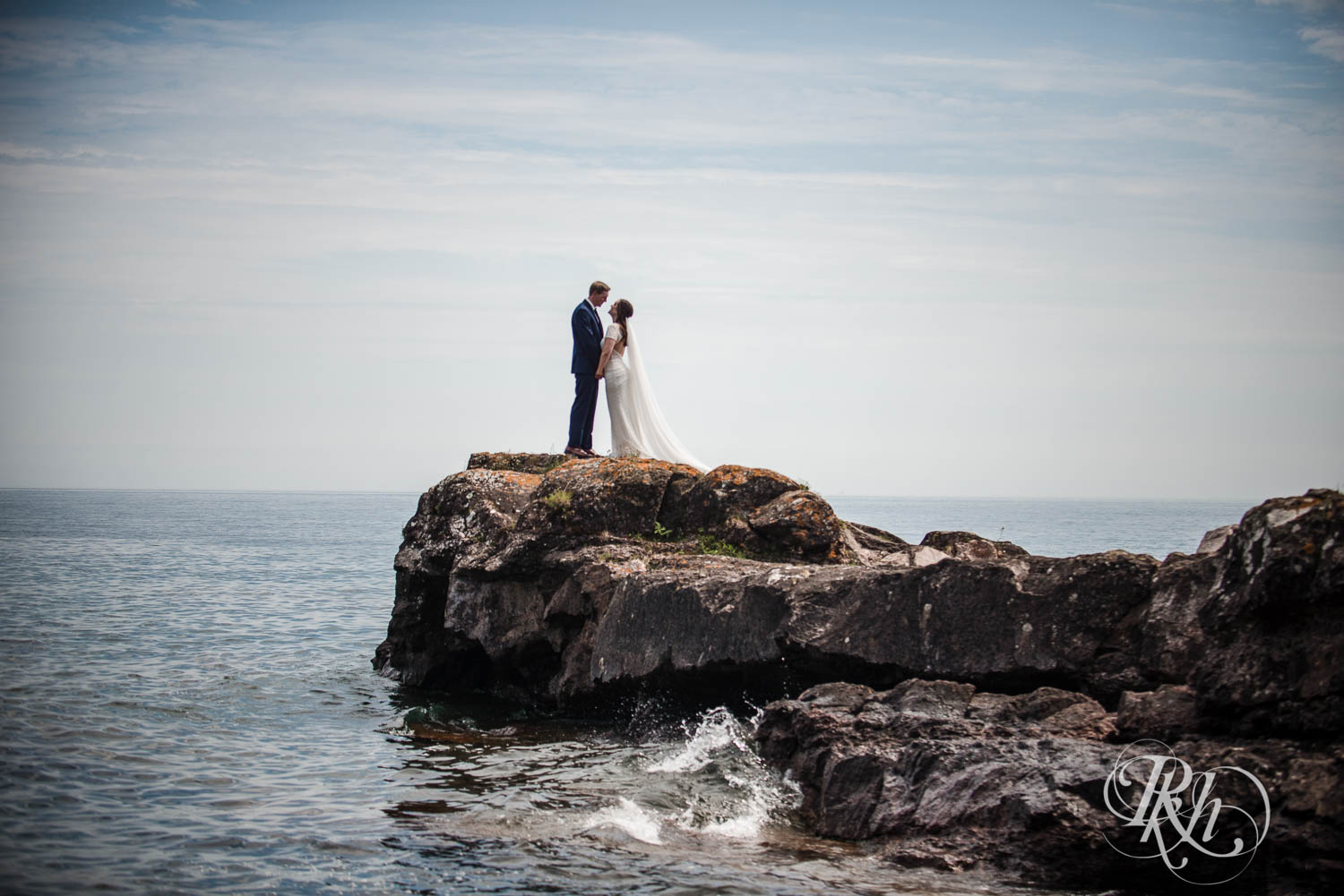 Bride and groom on cliff on Lake Superior