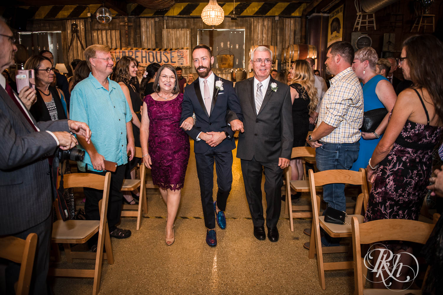 Groom walks down the aisle with parents at Warehouse Winery wedding in Saint Louis Park, Minnesota.