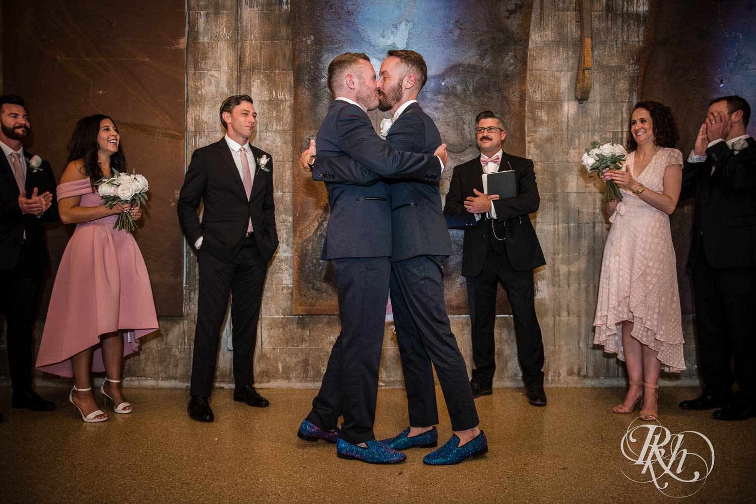 Grooms kiss during LGBTQ wedding ceremony at Warehouse Winery wedding in Saint Louis Park, Minnesota.