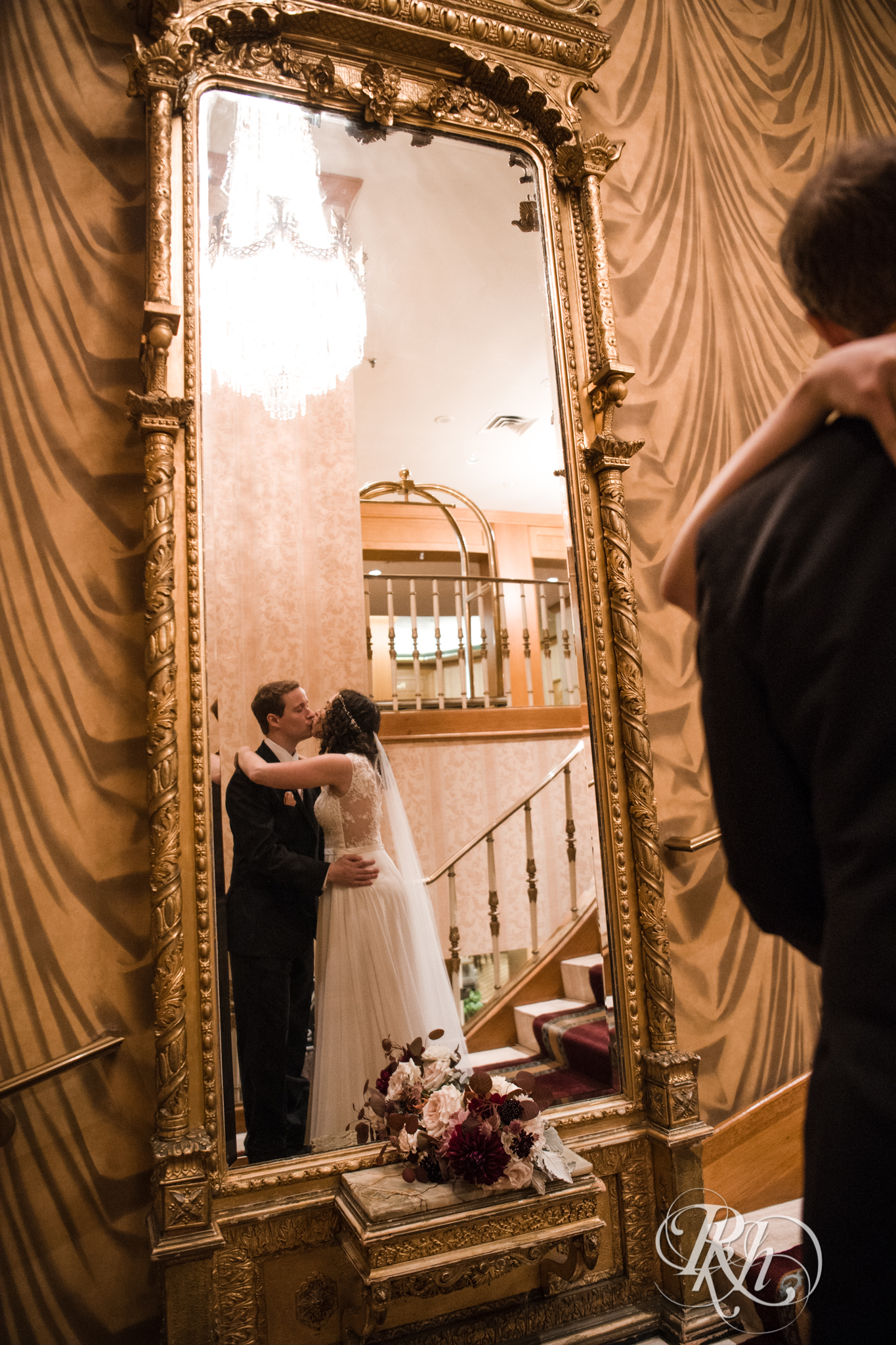 Bride and groom kiss in front of mirror at the Saint Paul Hotel in Saint Paul, Minnesota.
