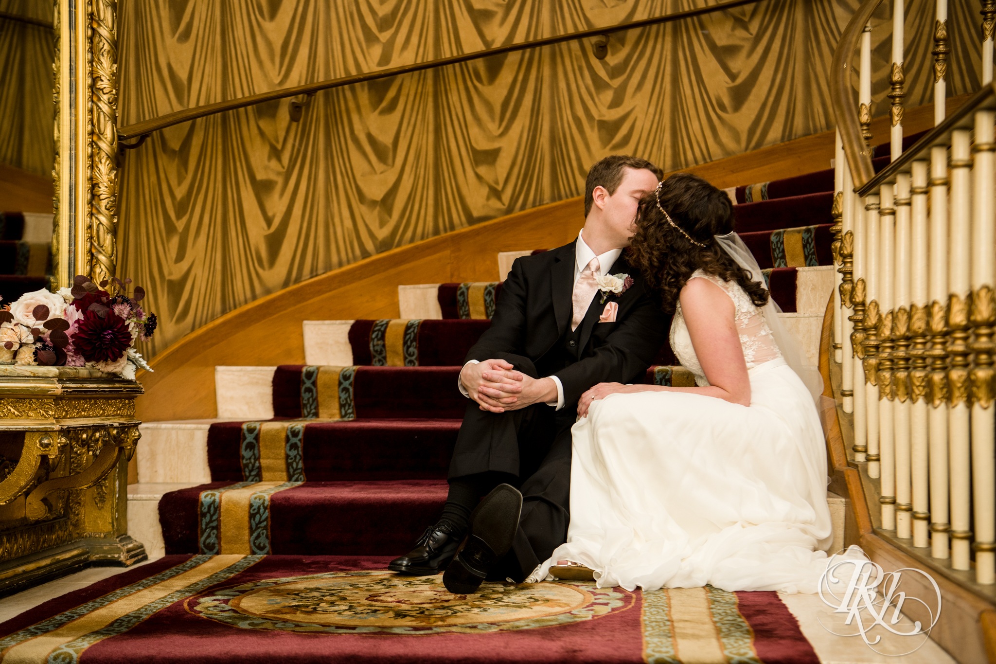 Bride and groom kiss on stairs at the Saint Paul Hotel in Saint Paul, Minnesota.