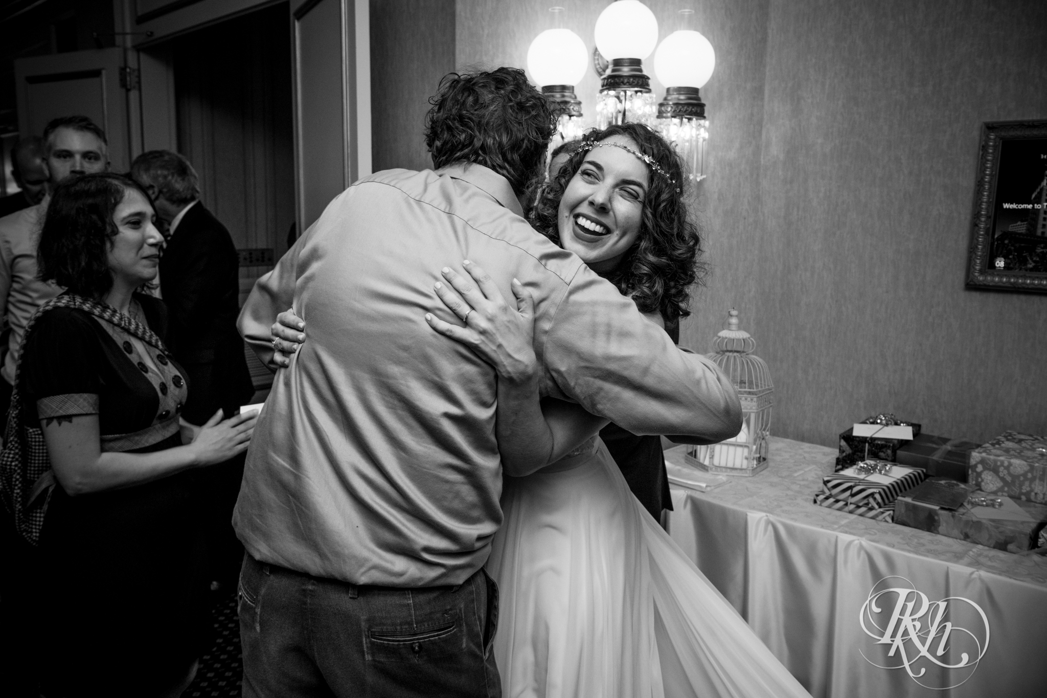 Guests hug bride during cocktail hour at the Saint Paul Hotel in Saint Paul, Minnesota.