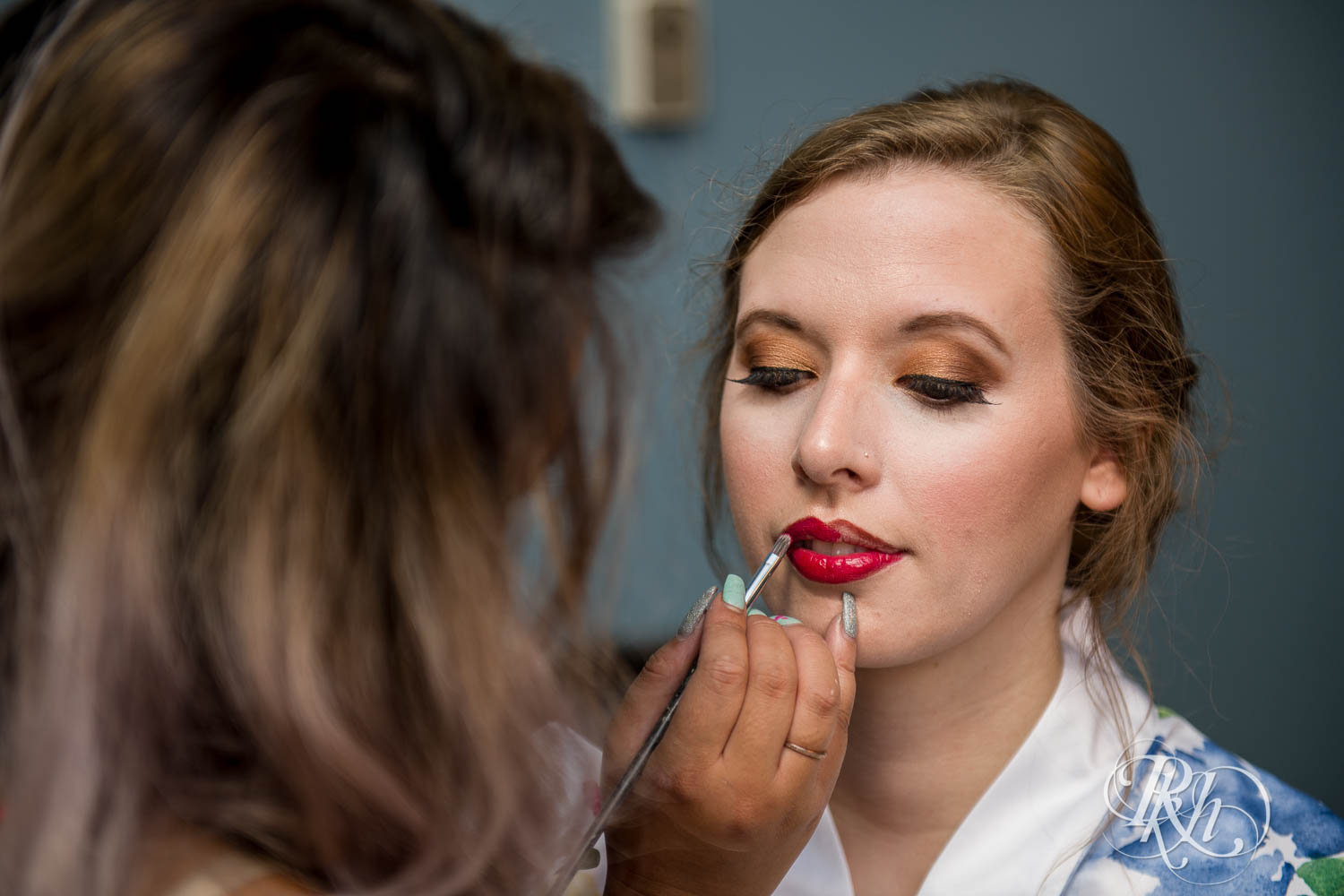 Bride getting makeup done before wedding at Plymouth Creek Center in Plymouth, Minnesota.