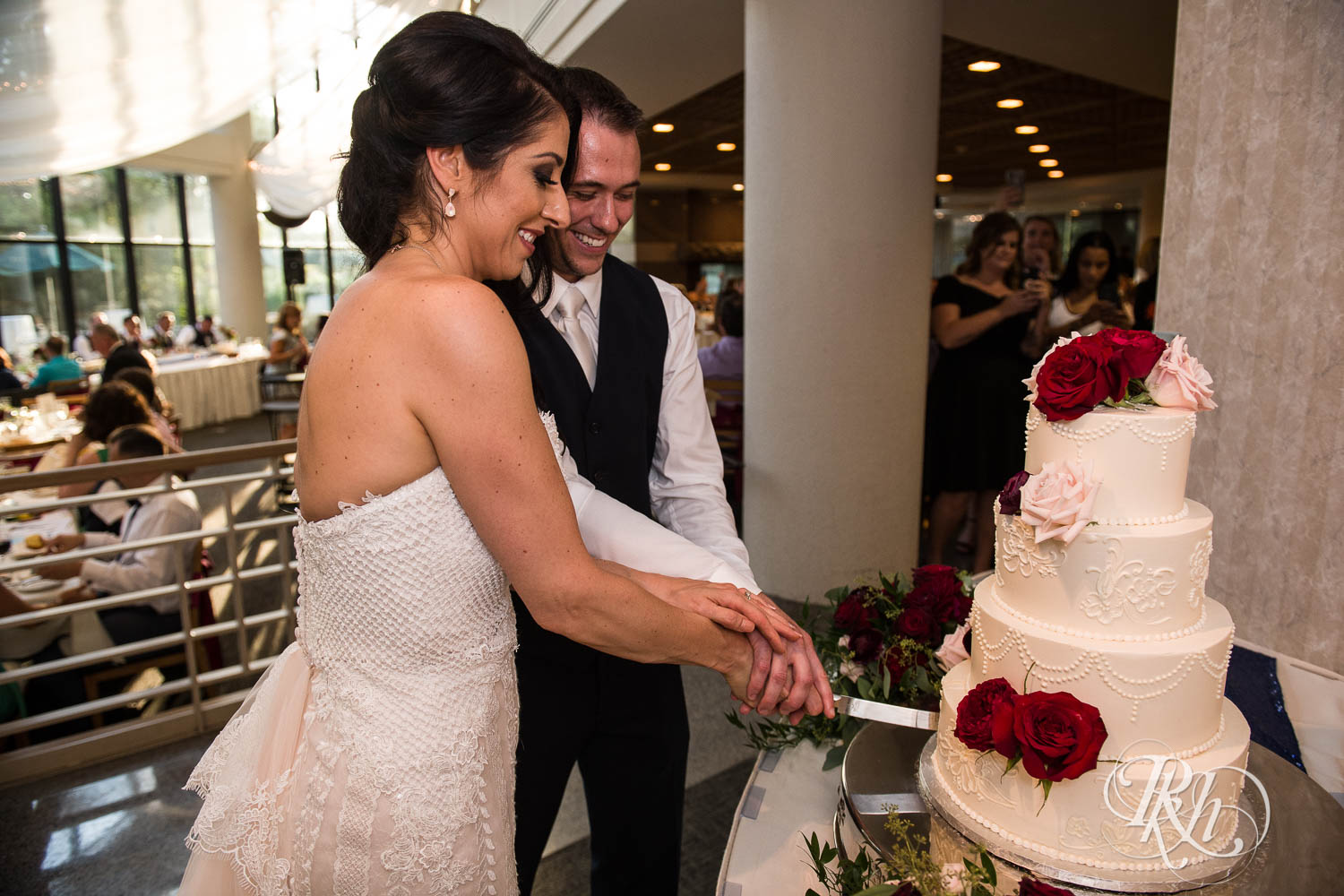 Bride and groom cut cake during wedding reception in Chaska, Minnesota.