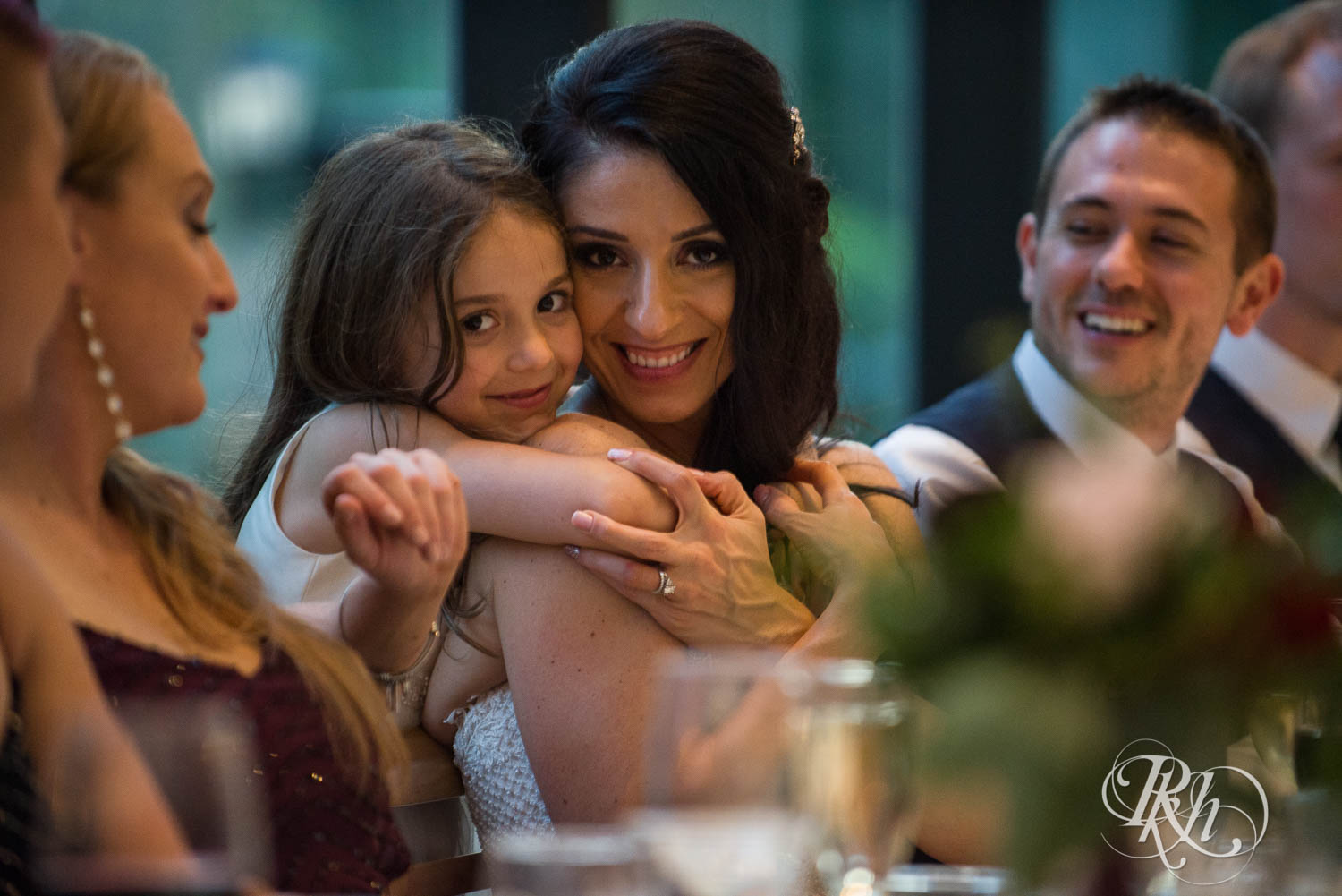 Bride's daughter hugs her during wedding reception in Chaska, Minnesota.