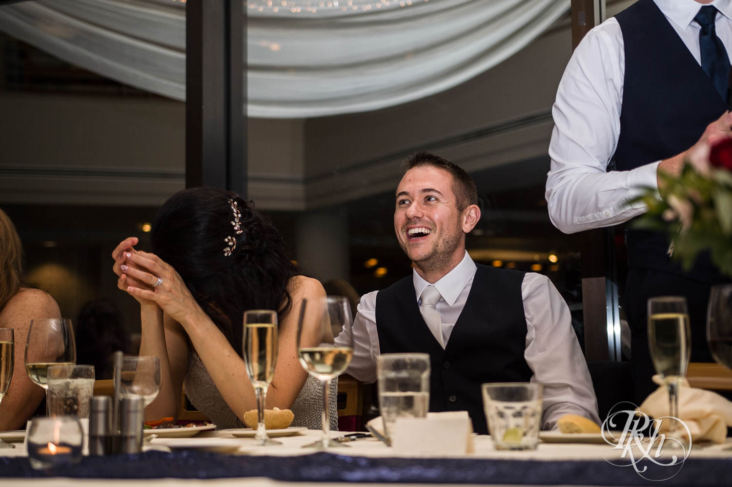 Bride and groom laugh during wedding reception in Chaska, Minnesota.