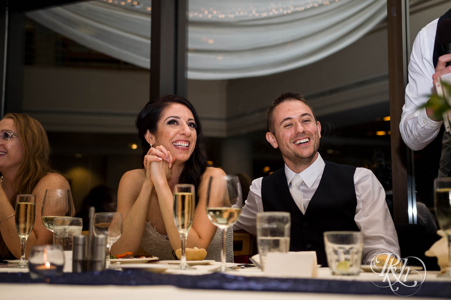Bride and groom laugh during wedding reception in Chaska, Minnesota.