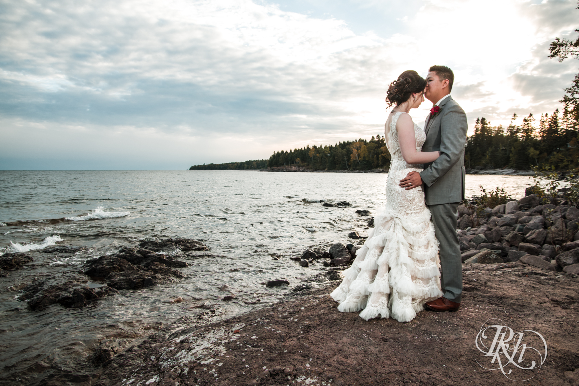 Bride and groom kiss at sunset at Grand Superior Lodge in Two Harbors, Minnesota.
