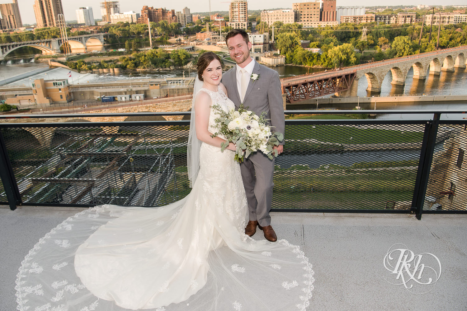 Bride and groom smile at sunset on top of Mill City Museum in Minneapolis, Minnesota.