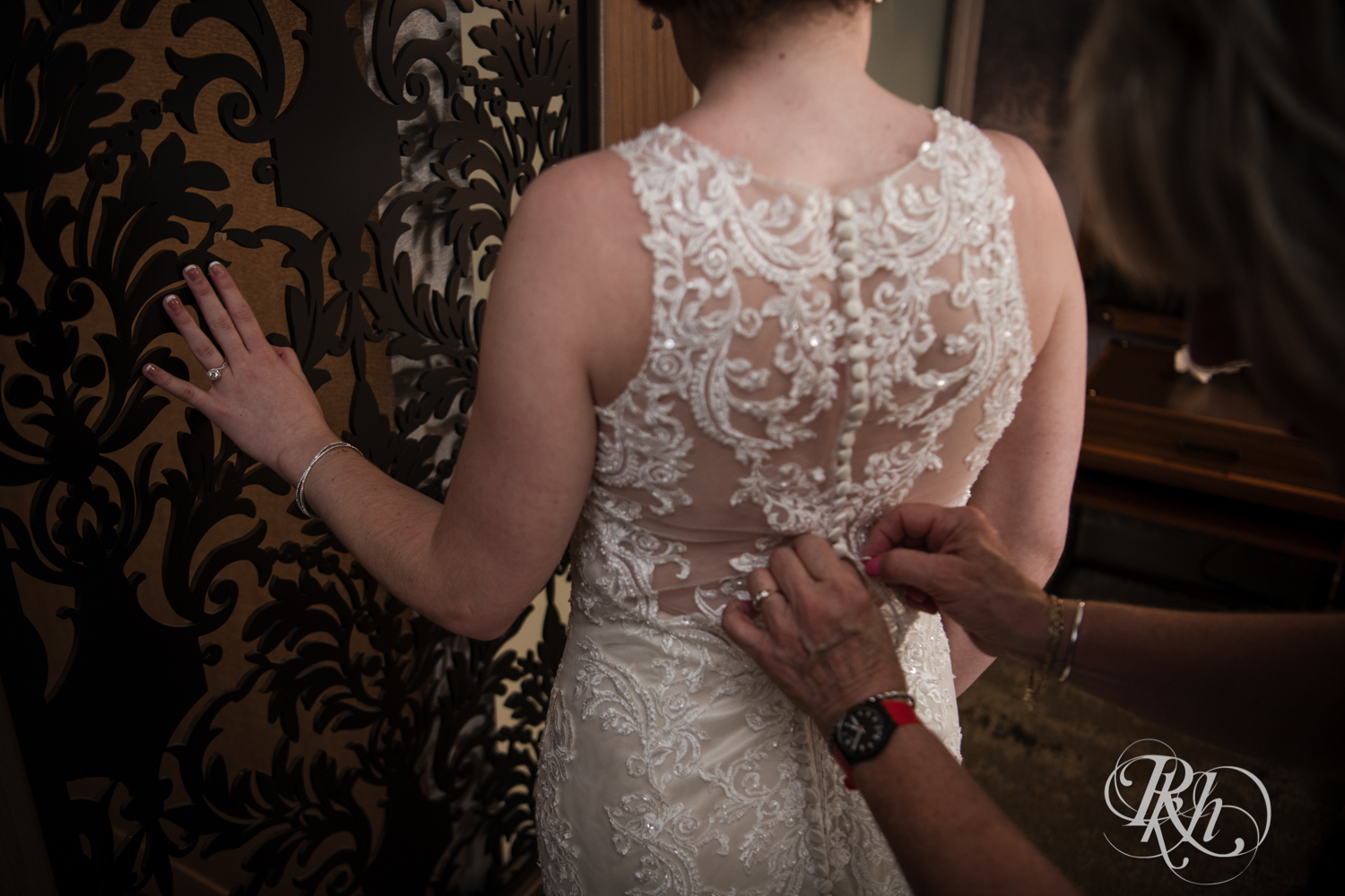 Bride getting buttoned into dress before wedding in Renaissance Hotel in Minneapolis, Minnesota. 