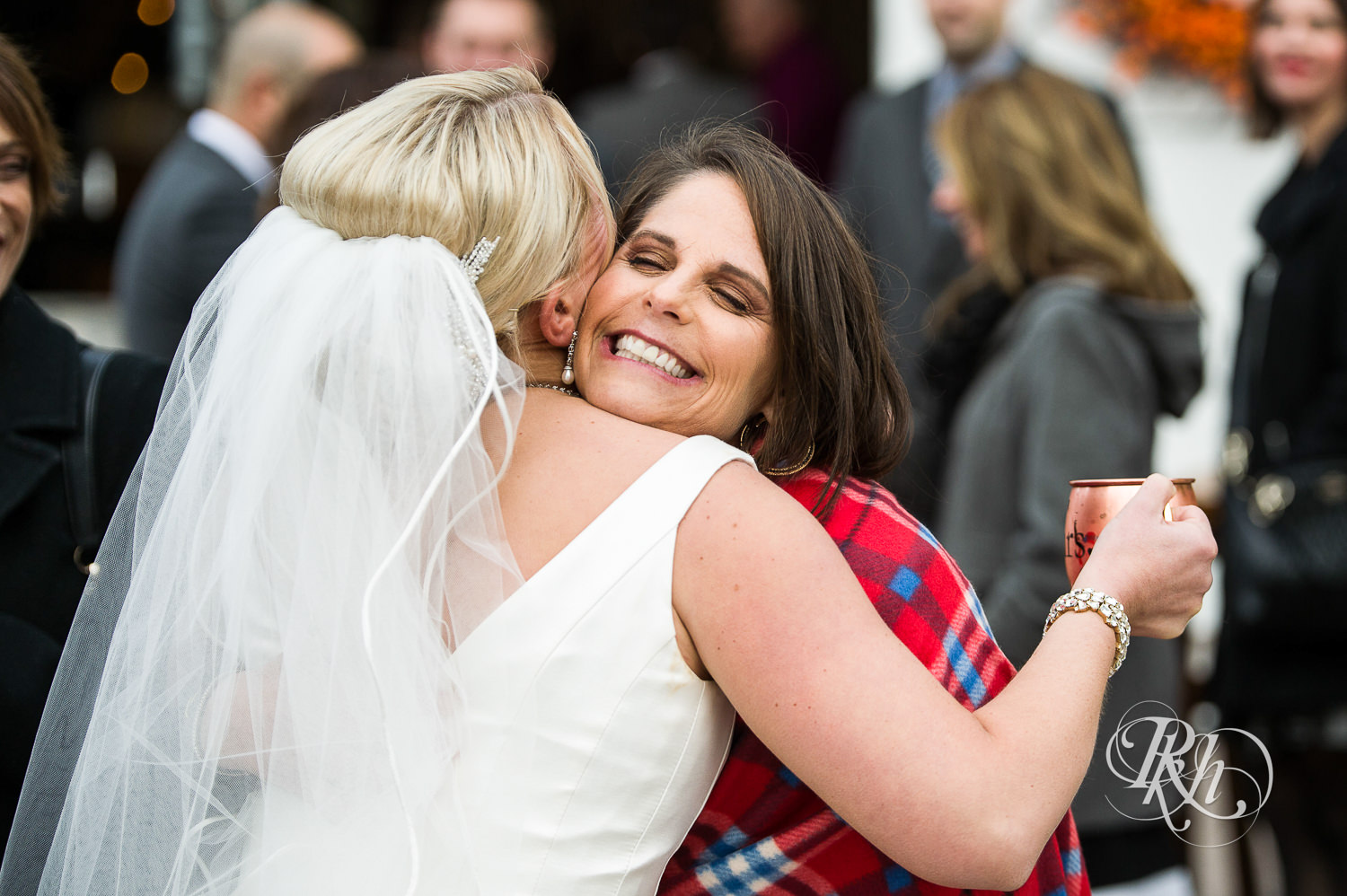 Guests hug the bride at Mayowood Stone Barn in Rochester, Minnesota.