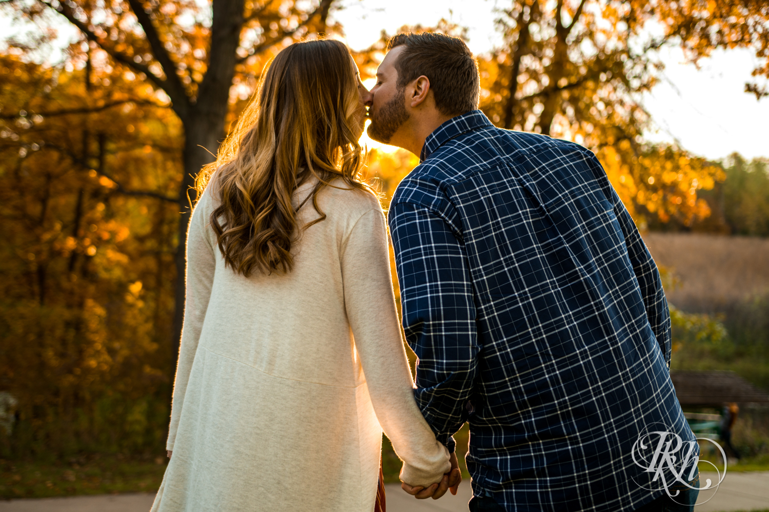 Man and woman kiss during golden hour engagement photos at Lebanon Hills in Eagan, Minnesota.
