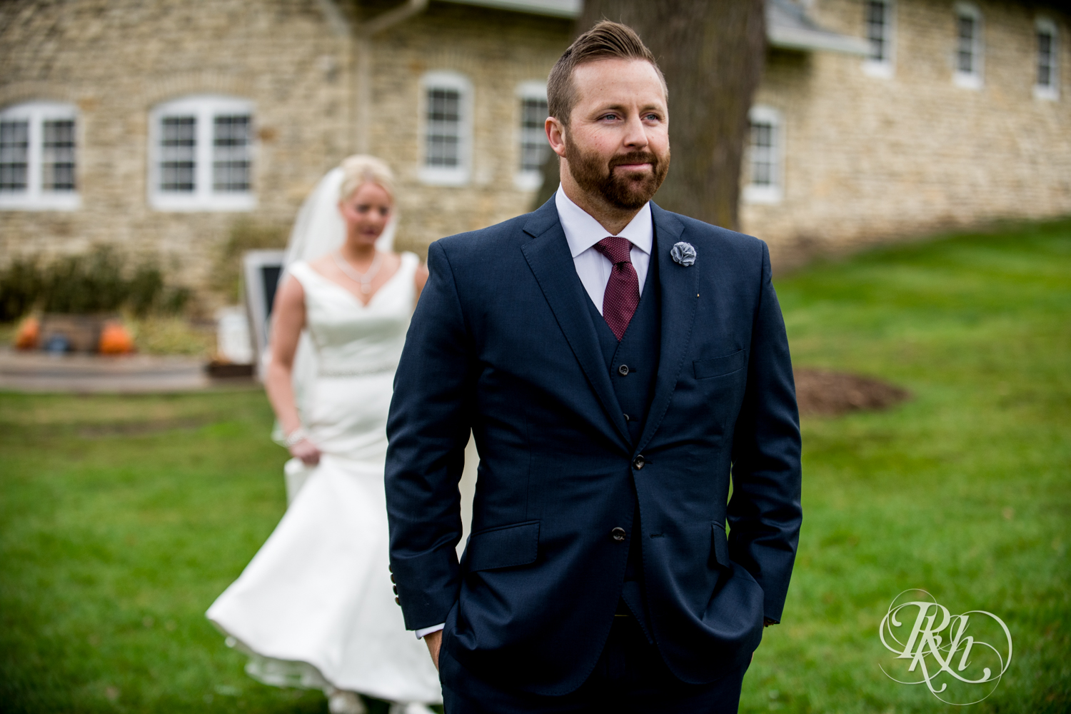 Groom waiting to see bride during first look at Mayowood Stone Barn in Rochester, Minnesota.