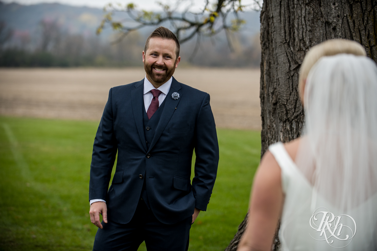 Groom sees bride during first look at Mayowood Stone Barn in Rochester, Minnesota.