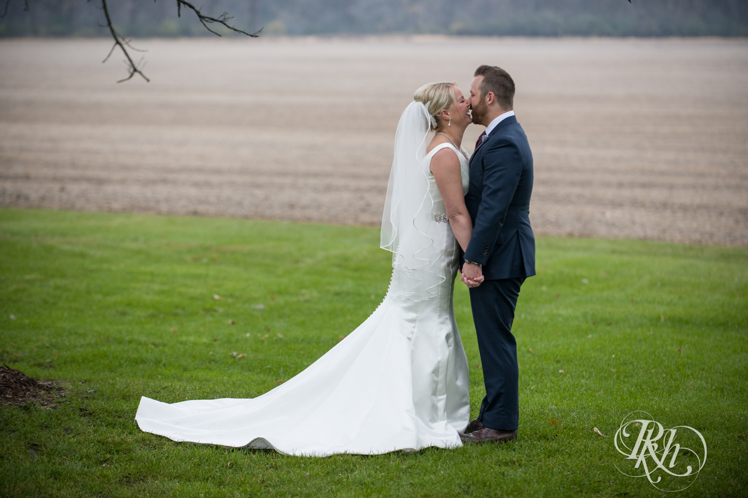 Bride and groom kiss at Mayowood Stone Barn in Rochester, Minnesota.