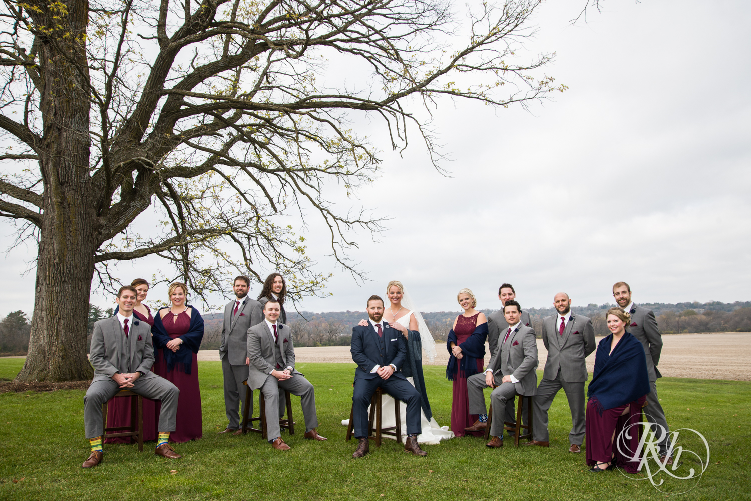 Wedding party smile under tree at Mayowood Stone Barn in Rochester, Minnesota.
