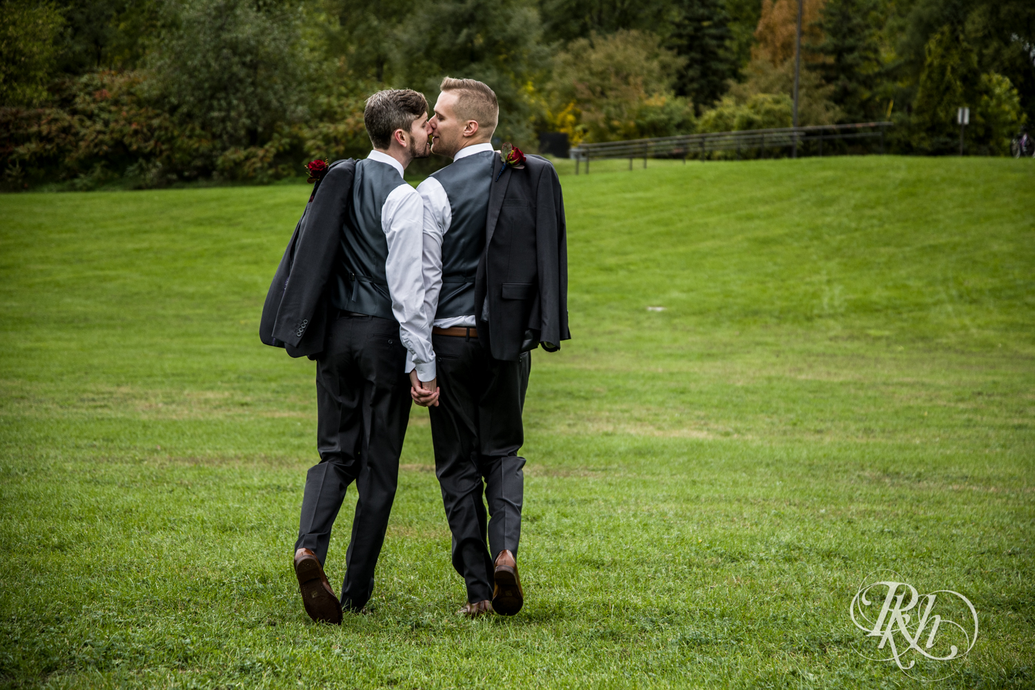 Grooms kiss at Bohemian Flats Park in Minneapolis, Minnesota for Minnesota LGBT wedding photographer.