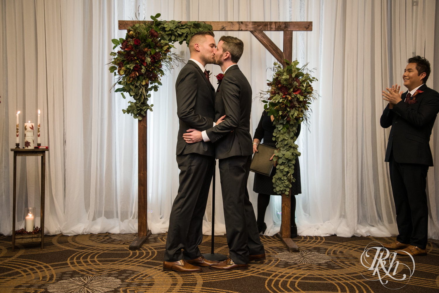 Grooms kiss during LGBTQ wedding ceremony at Courtyard by Marriott Minneapolis.