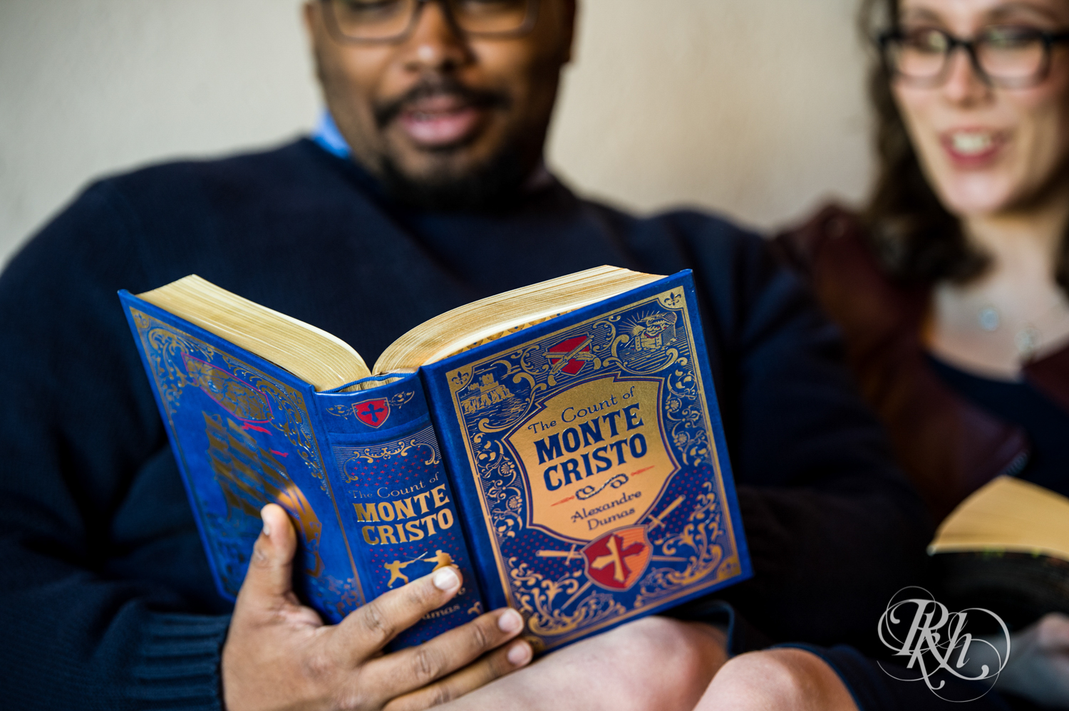 Black man and white woman read books during geeky engagement photography in Saint Paul, Minnesota.