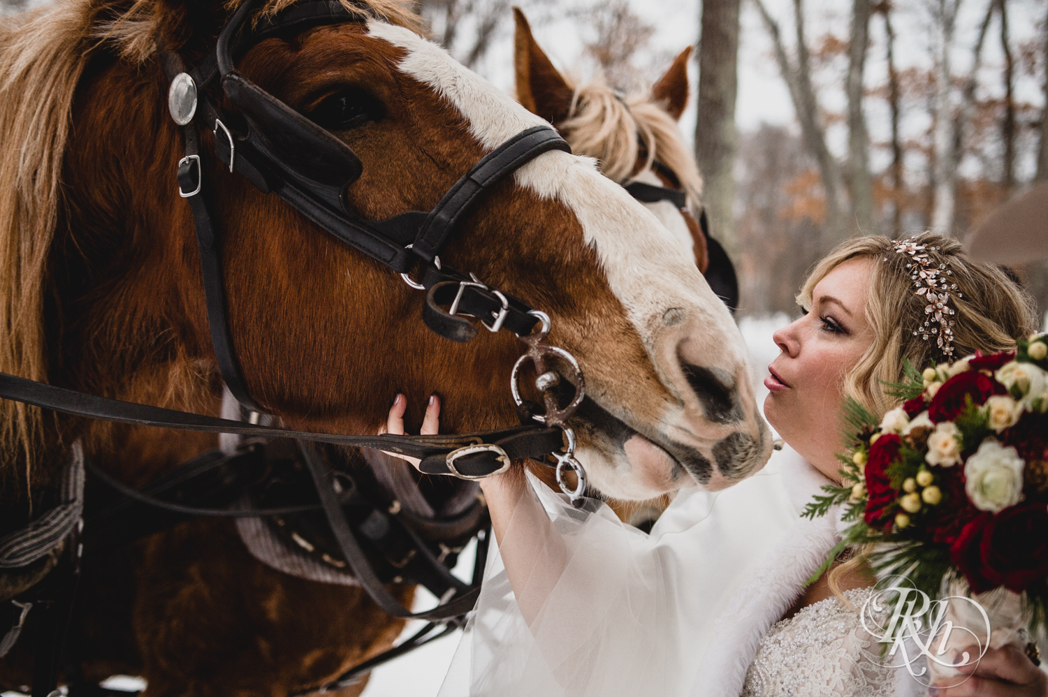 Bride coos horses during winter wedding at Whitefish Lodge in Crosslake, Minnesota.