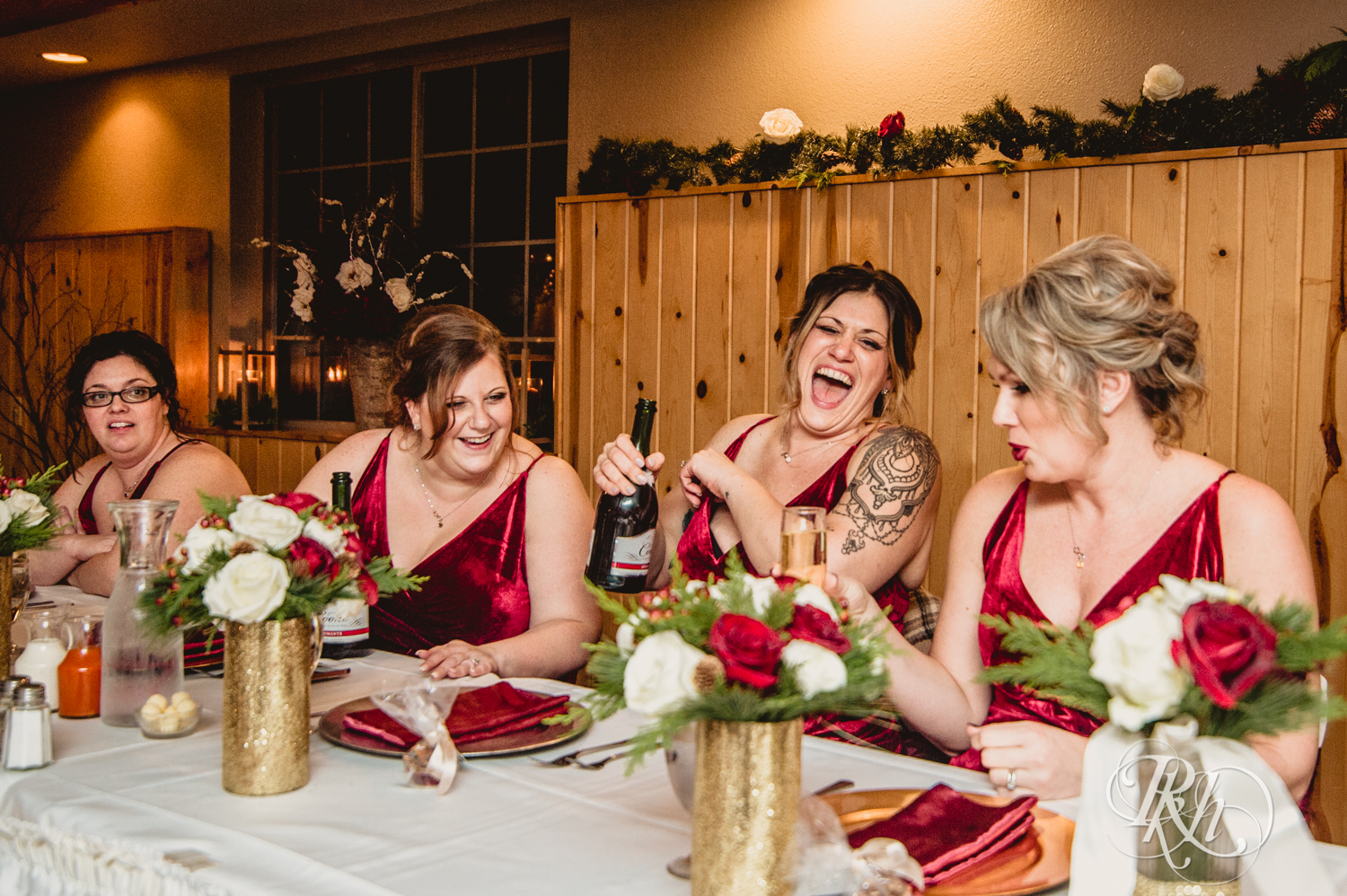 Wedding party laughs during winter wedding reception at Whitefish Lodge in Crosslake, Minnesota.