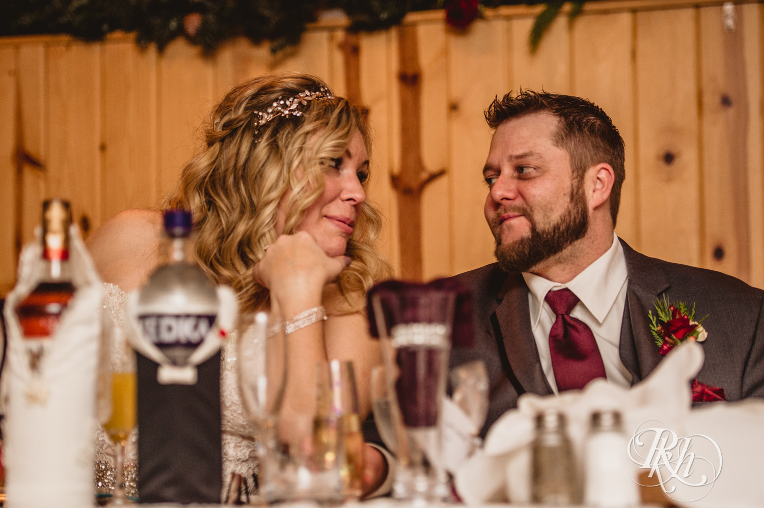 Bride and groom smile during winter wedding reception at Whitefish Lodge in Crosslake, Minnesota.
