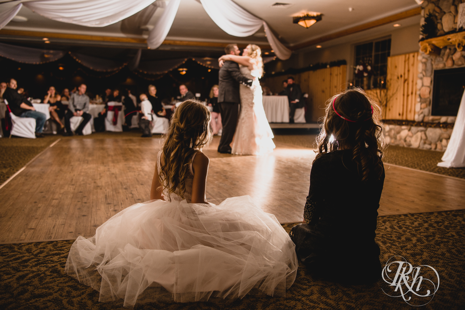 Girls watch bride and groom have first dance during winter wedding reception at Whitefish Lodge in Crosslake, Minnesota.