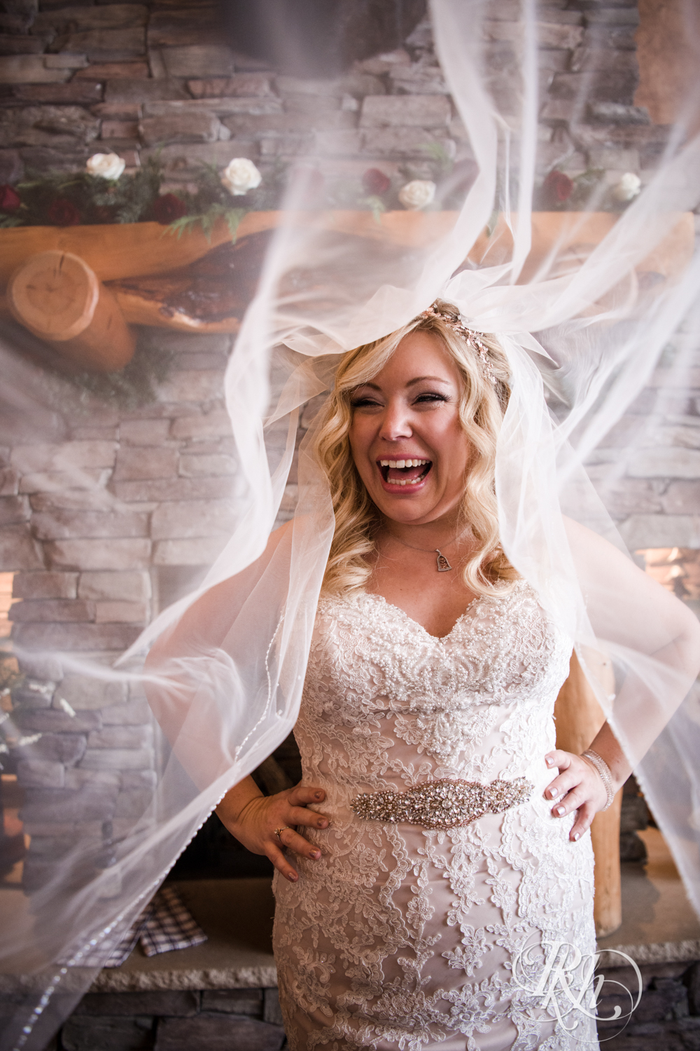 Bride smiles under veil during winter wedding at Whitefish Lodge in Crosslake, Minnesota.
