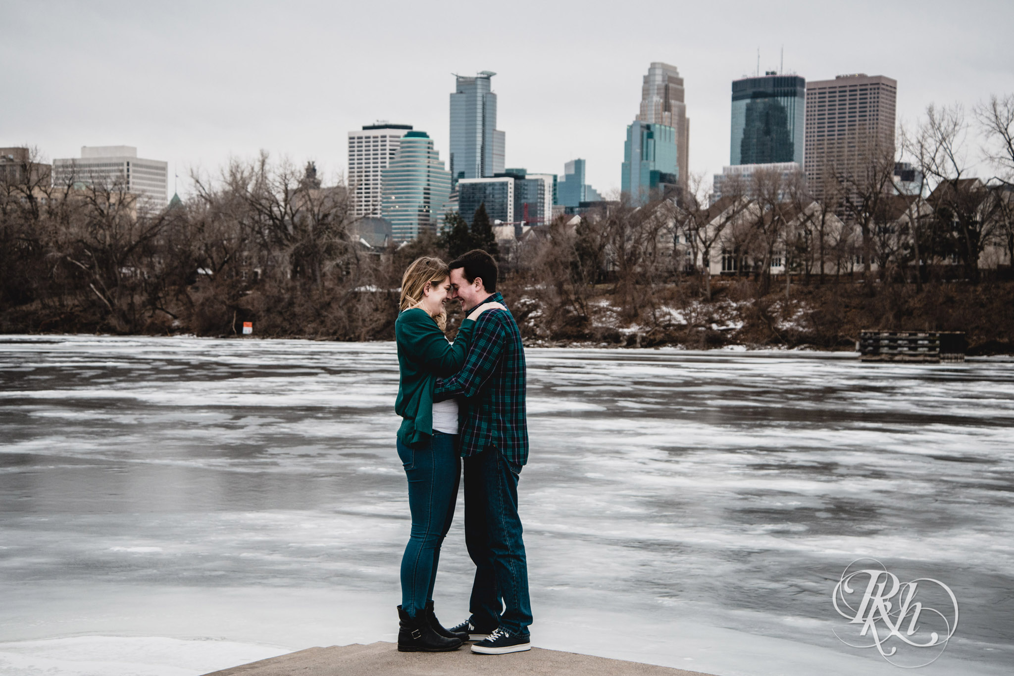 Man and woman smile on windy day in Boom Island Park in Minneapolis, Minnesota.