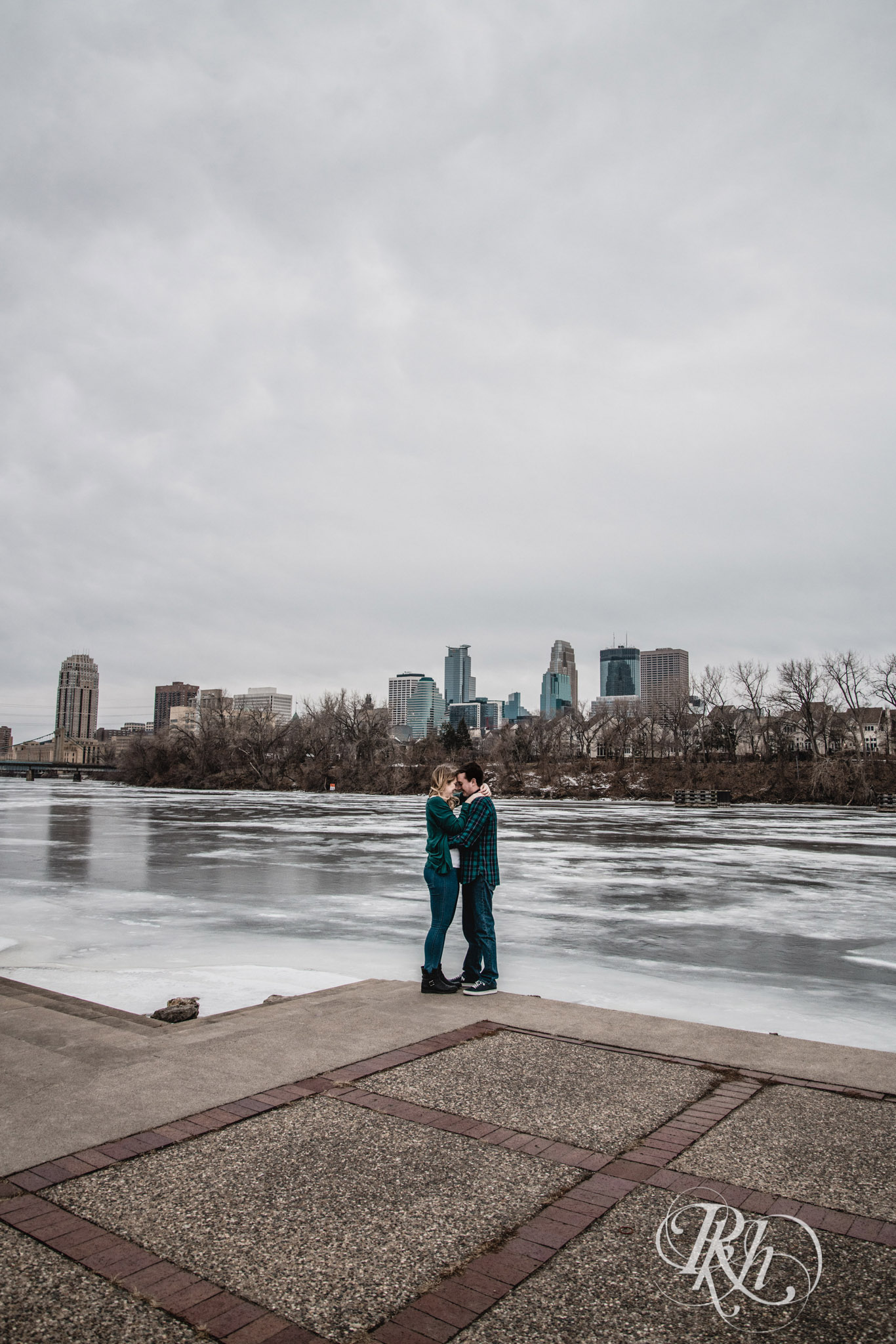 Man and woman smile on windy day in Boom Island Park in Minneapolis, Minnesota.