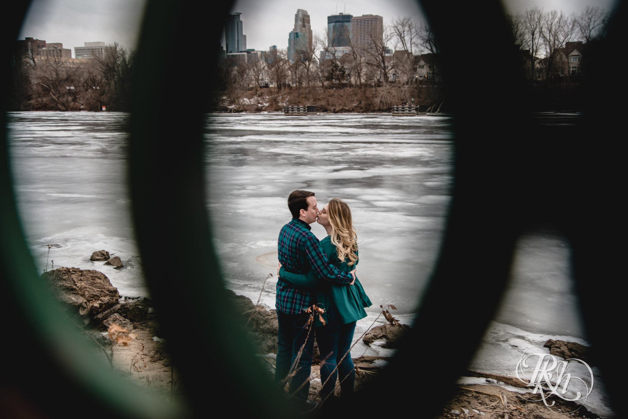 Man and woman kiss on windy day in Boom Island Park in Minneapolis, Minnesota.