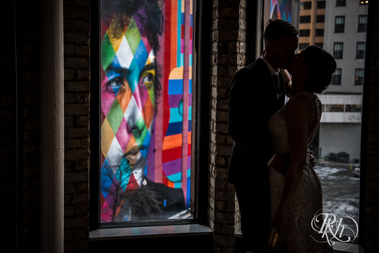 Bride and groom kiss in front of the Bob Dylan mural in Minneapolis, Minnesota.