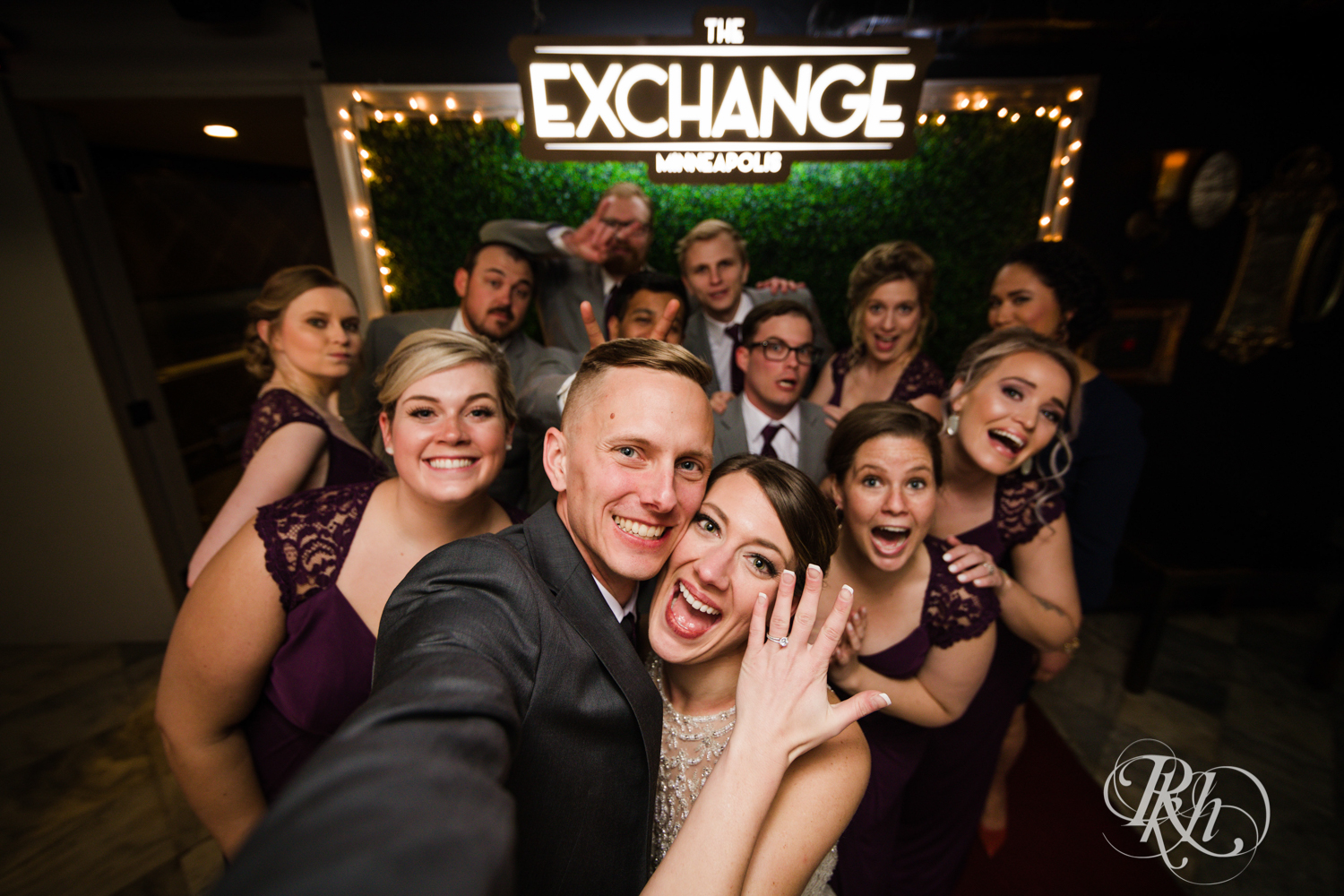 Bride and groom smile with wedding party in the Lumber Exchange Event Center in Minneapolis, Minnesota.
