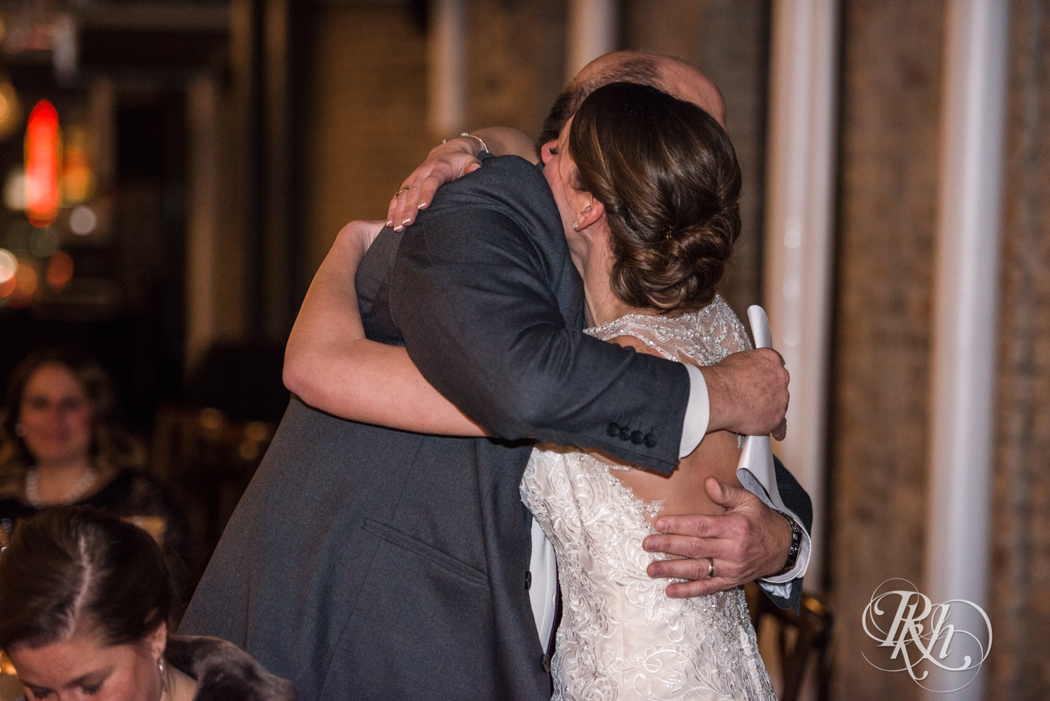 Bride hugs dad during speeches at wedding reception at the Lumber Exchange Event Center in Minneapolis, Minnesota.