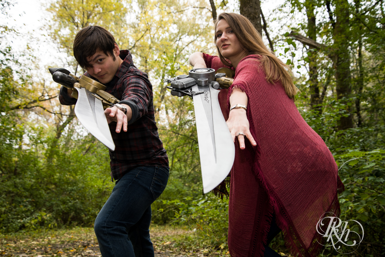 Man and woman flash swords at camera during cosplay engagement photography in Minneapolis, Minnesota.
