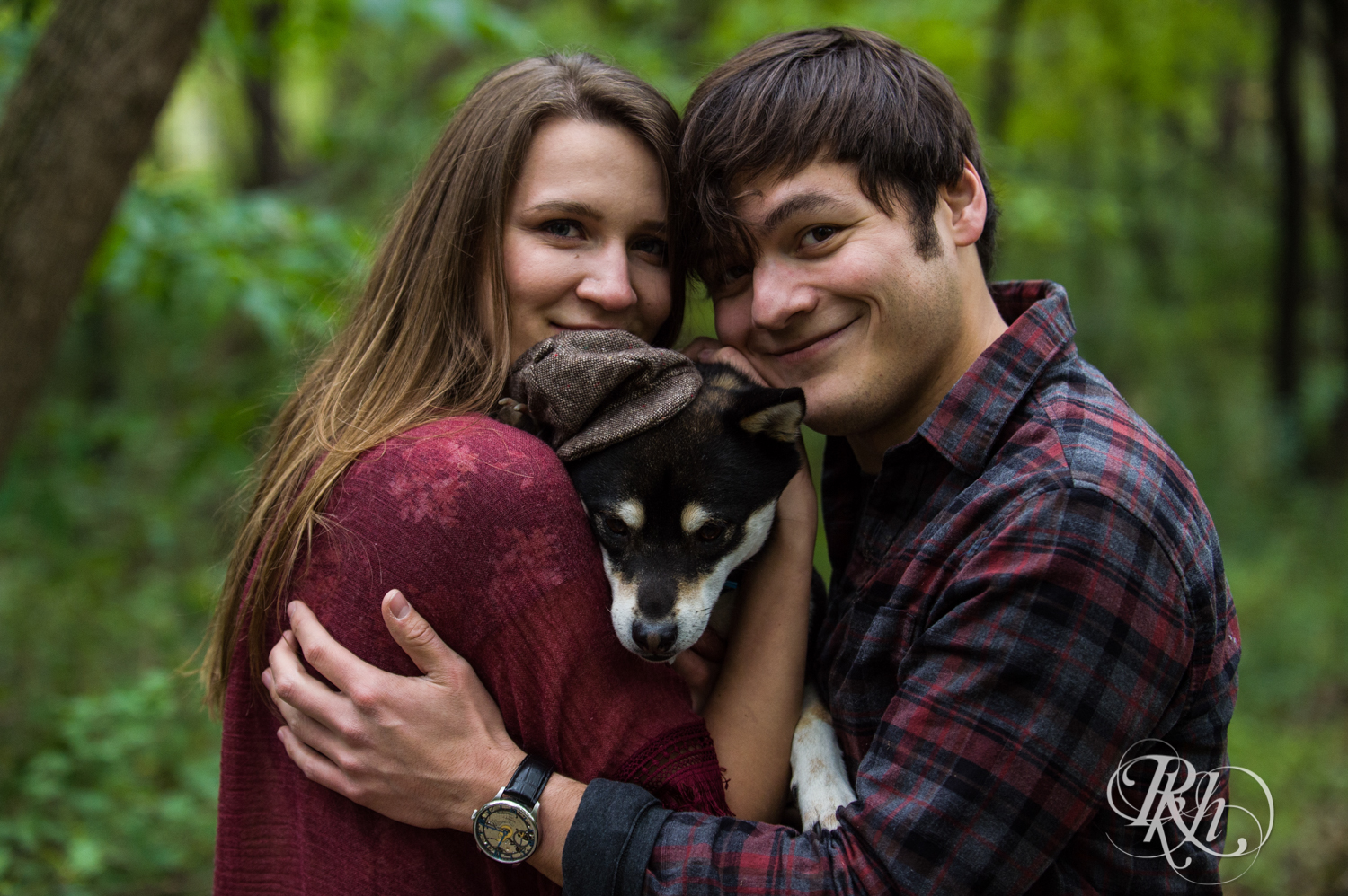 Man and woman snuggle their Shiba Inu puppy in Minneapolis, Minnesota woods.