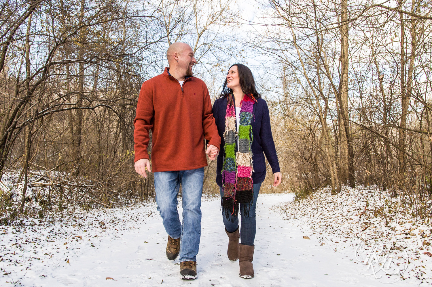 Man and woman smile while walking in snow in Hidden Valley Park in Savage, Minnesota.