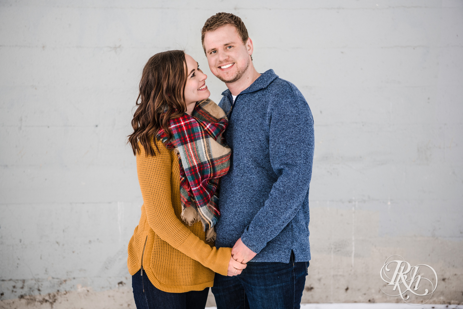 Man and woman smile during winter engagement photography in Minneapolis, Minnesota.