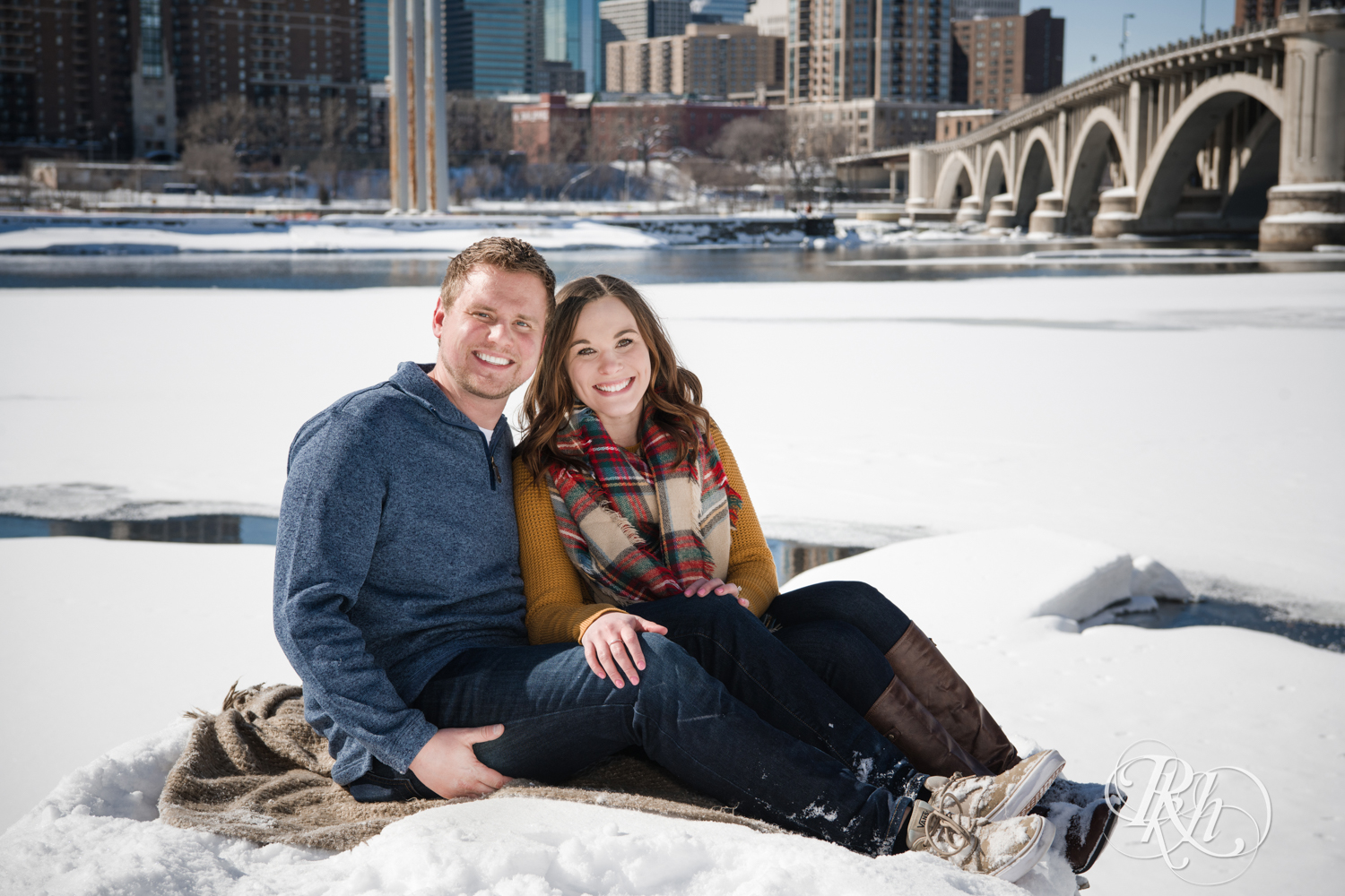 Man and woman smile during winter engagement photography in Minneapolis, Minnesota.
