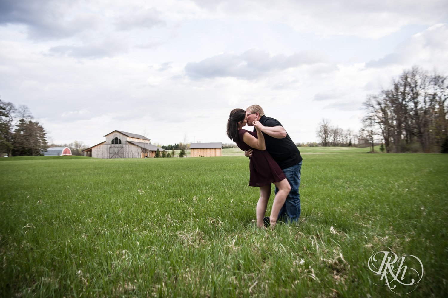 Man and woman kiss in field at Creekside Farm and Events in Rush City, Minnesota.