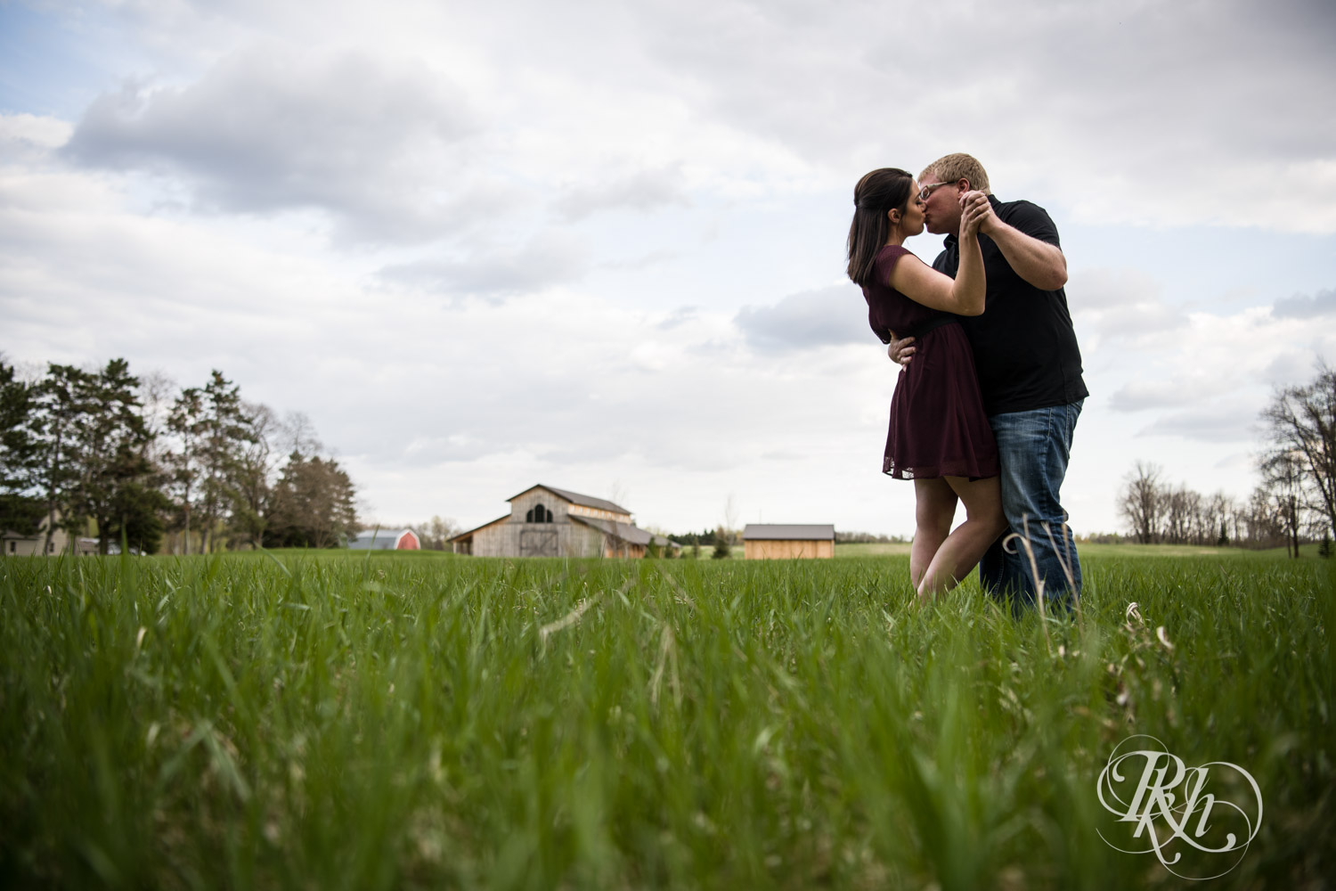 Man and woman kiss in field at Creekside Farm and Events in Rush City, Minnesota.