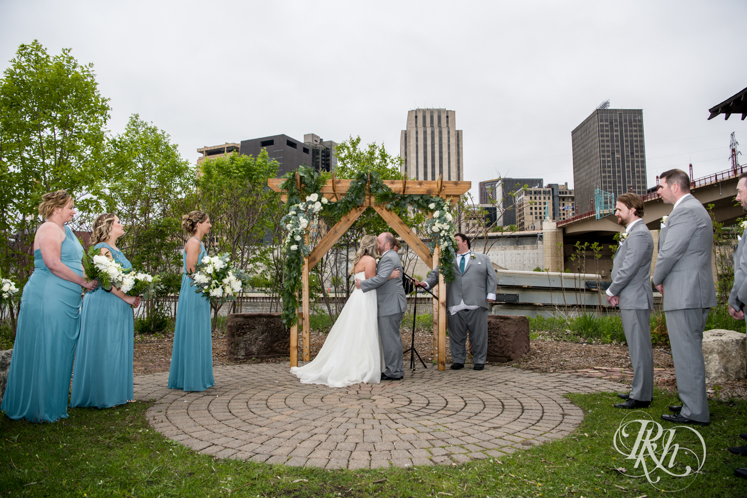 Bride and groom kiss at wedding ceremony at the Minnesota Boat Club on Raspberry Island in Saint Paul, Minnesota.
