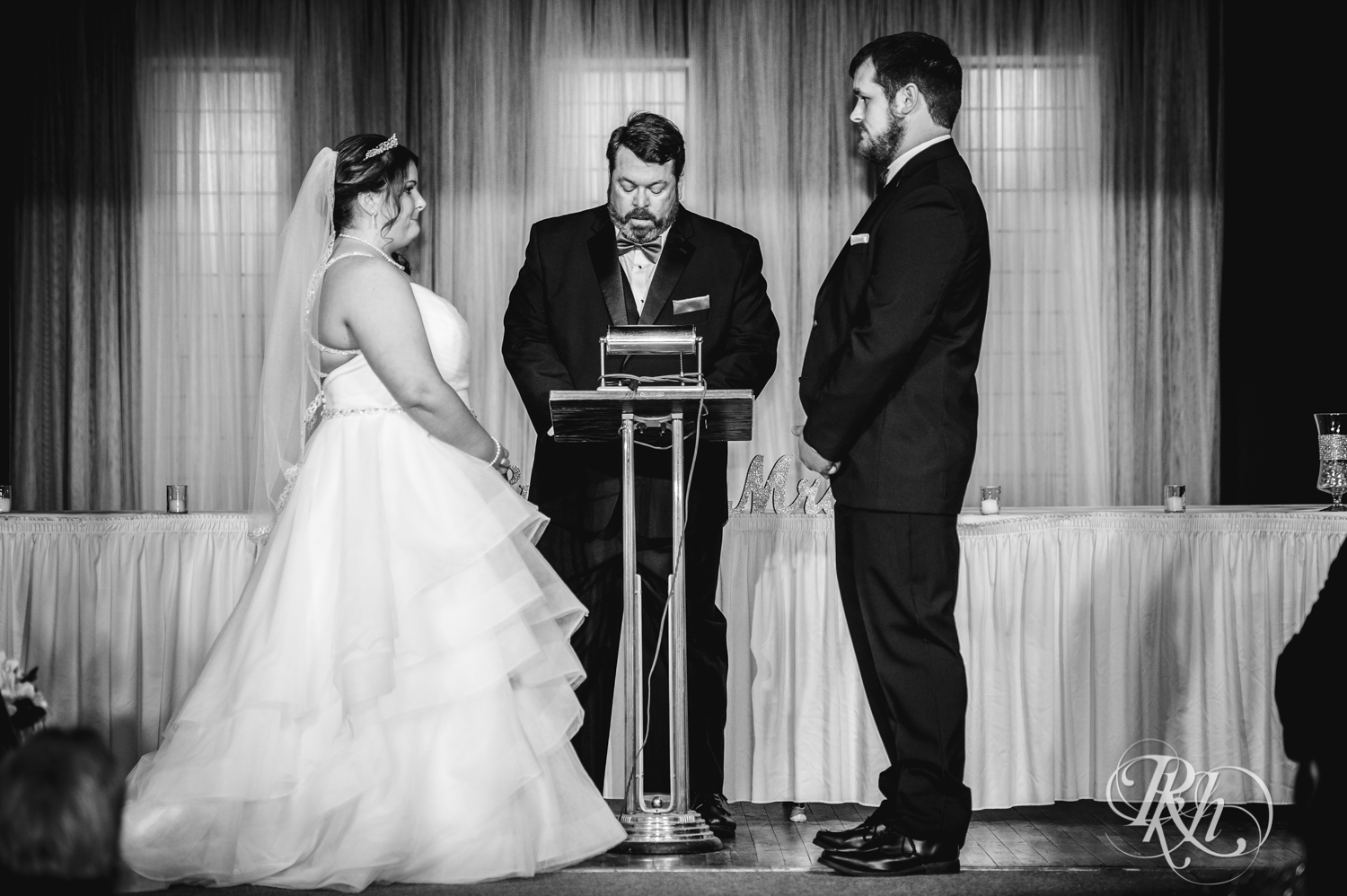 Bride and groom smile at wedding ceremony at Memories Ballroom in Port Washington, Wisconsin