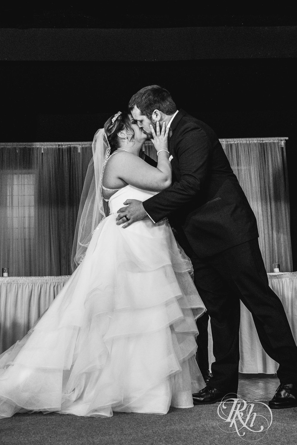 Bride and groom kiss at wedding ceremony at Memories Ballroom in Port Washington, Wisconsin
