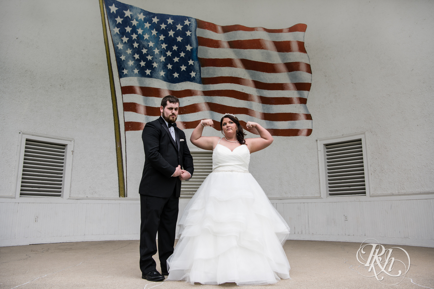 Bride and groom pose in front of American flag mural in Port Washington, Wisconsin