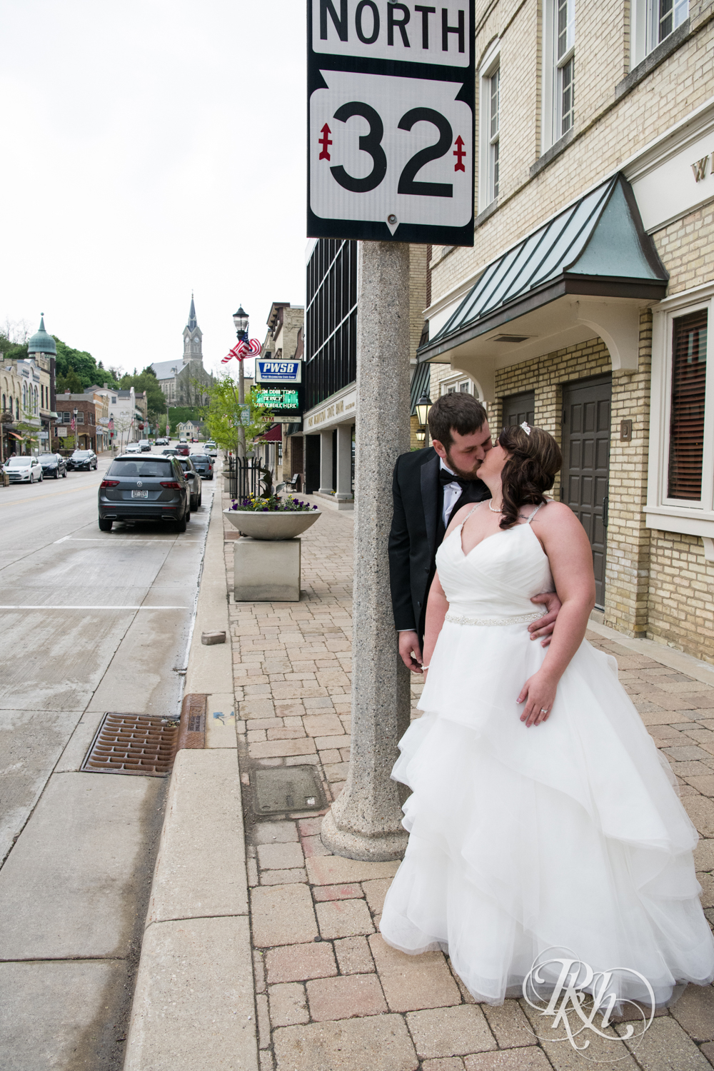Bride and groom kiss on the sidewalk in Port Washington, Wisconsin