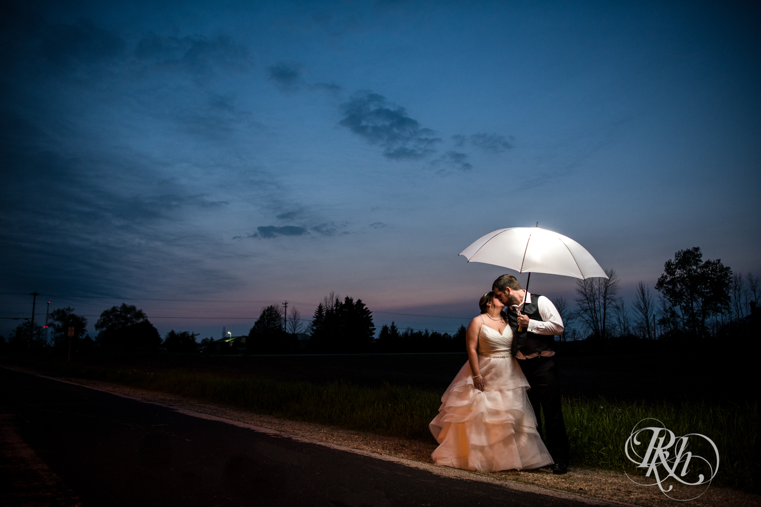 Bride and groom under umbrella night