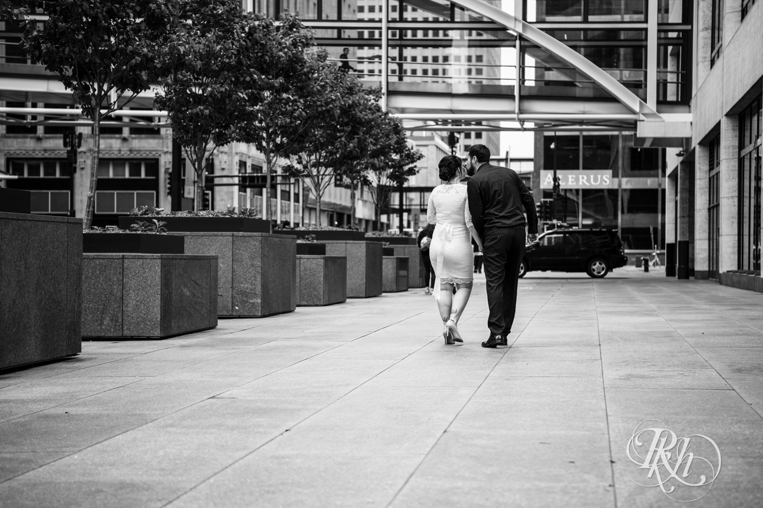 Bride and groom walk down sidewalk in Minneapolis, Minnesota before their courthouse wedding.