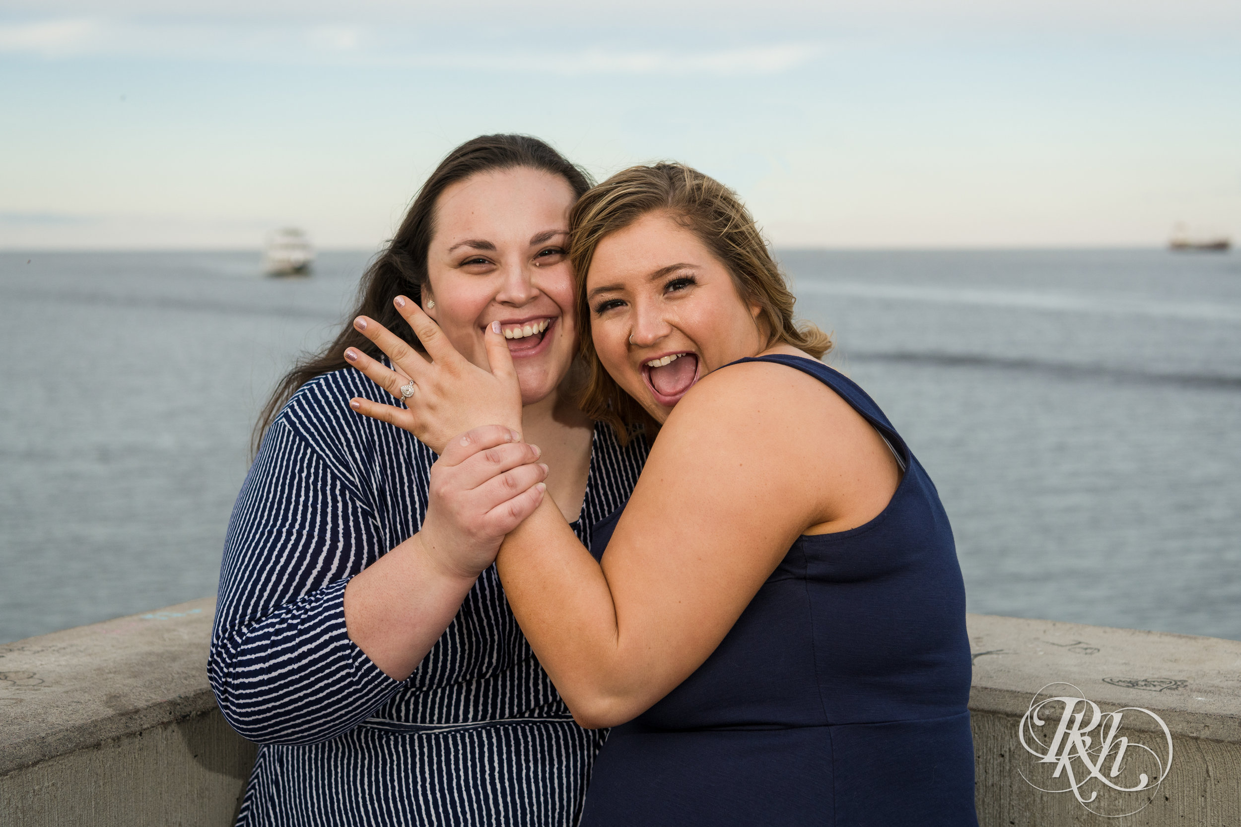 Lesbian couple laugh during engagement session in Duluth, Minnesota.