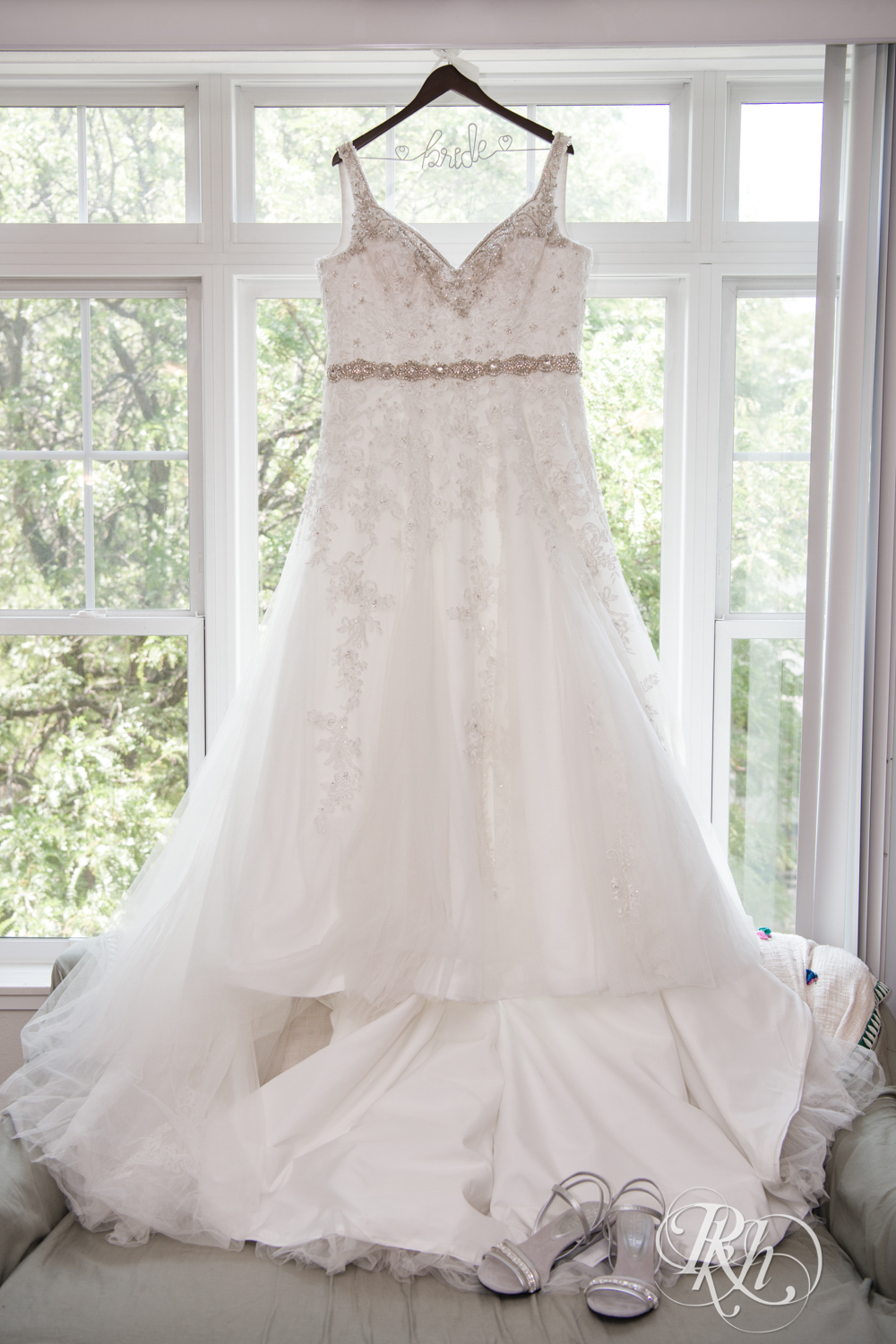 Wedding dress hanging in window.